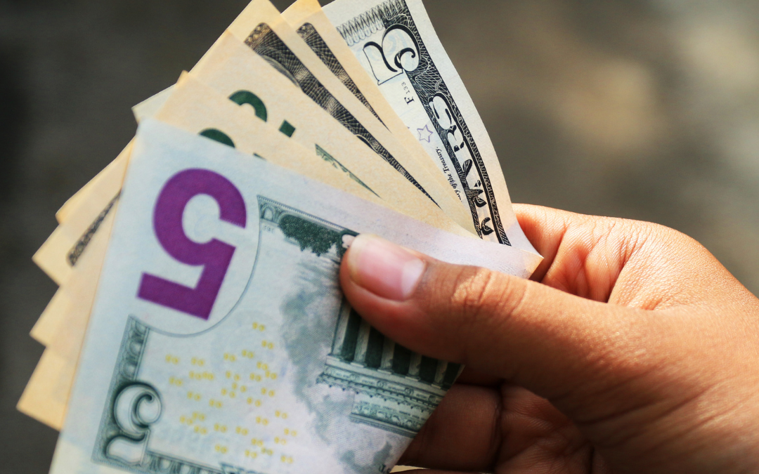 Hand holding fanned US dollar bills