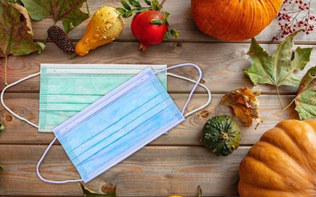 Surgical masks among pumpkins and autumn leaves
